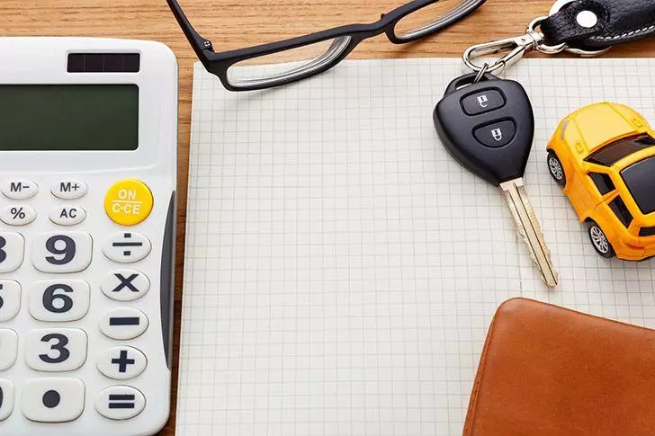 Notebook with car key and calculator